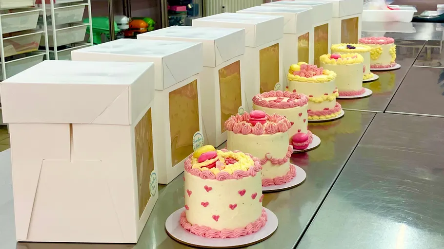 Kuchen mit rosa Dekorationen auf Metalltisch.