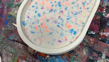 Oval tray with colorful speckles on table.