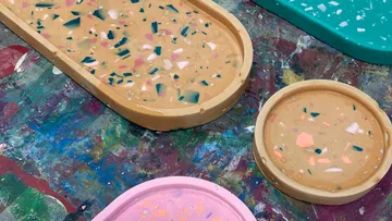 Assorted terrazzo trays on multicolored table.