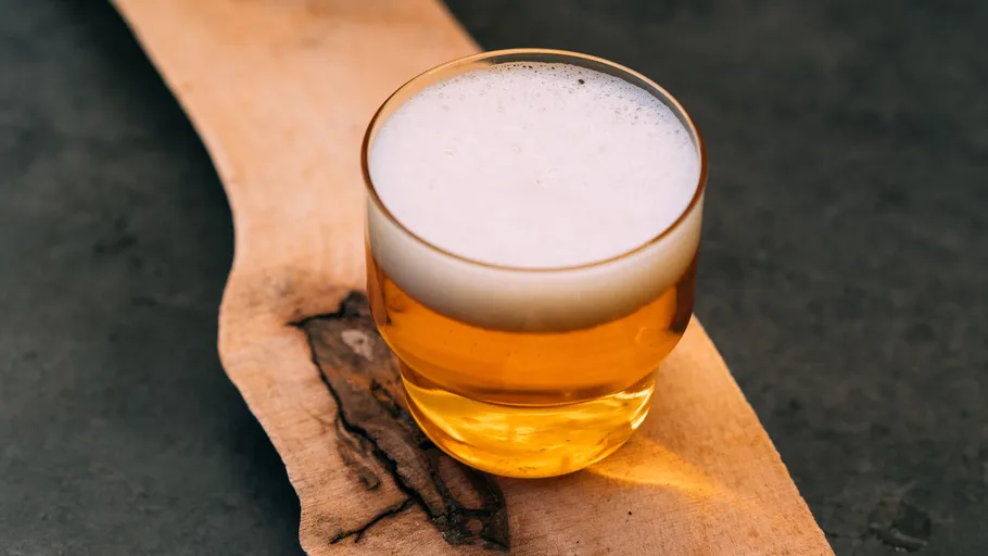 Glass of beer on wooden board.