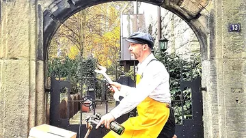 Mann auf Fahrrad mit Schraubenschlüssel draußen.