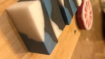 Soap bars stacked on wooden surface.