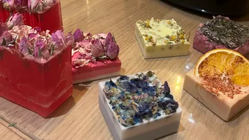 Dekorative Seifen mit Trockenblumen auf einem Tisch.