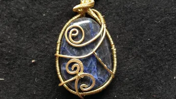 Stone pendant wrapped in gold wire.