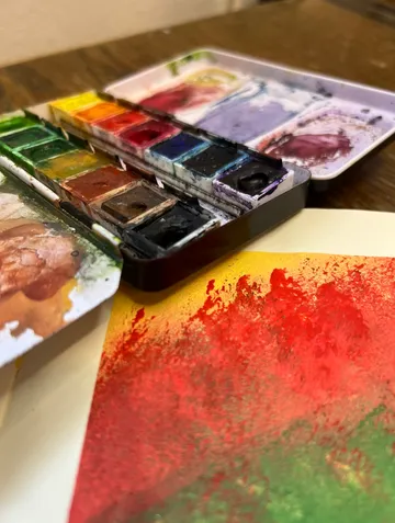 Aquarellpalette auf Holztisch.