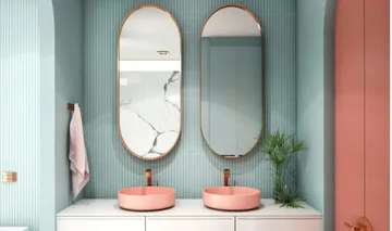 Badezimmer mit zwei Waschbecken, Spiegeln, rosa Akzenten.