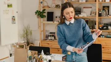 Woman examining a paper in an art studio.