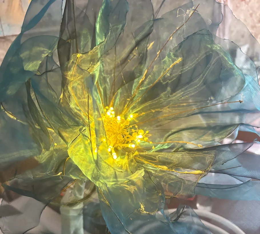 Fabric flower with glowing lights indoors.