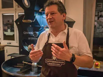 Man talks passionately about coffee roasting in a coffee factory.