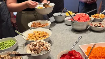 Personen bedienen sich an einem Buffet.
