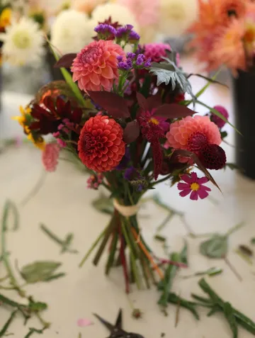 Blumenstrauß mit rosa Blumen auf Tisch.