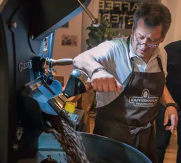 Coffee roaster produces freshly roasted beans in a roastery.