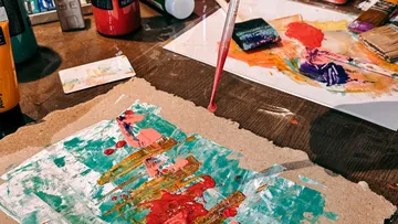 Bunte Kunstmaterialien auf dem Tisch verteilt.