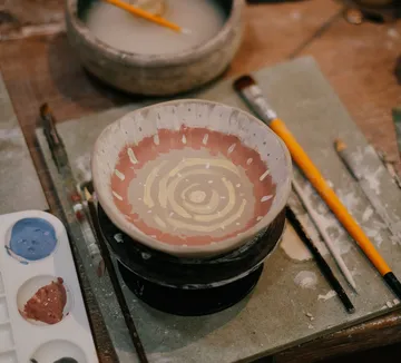 Painted ceramic bowl on an artist's table.