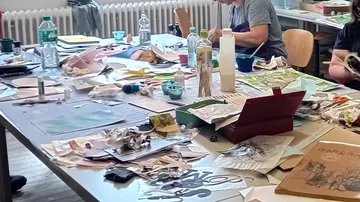 Menschen basteln an einem unordentlichen Tisch.