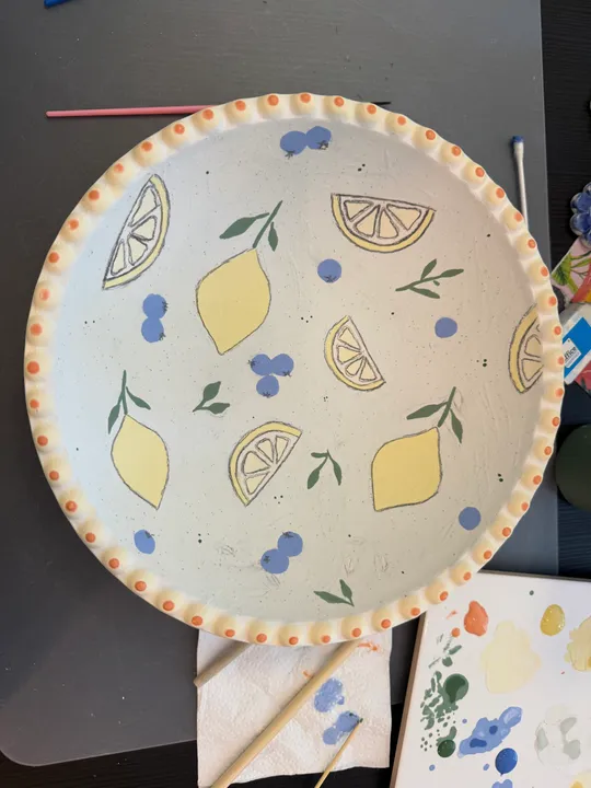 Painted plate with lemons and blueberries.