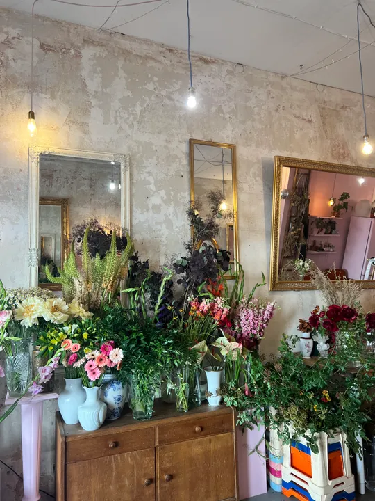 Blumen in Vasen auf Holzschrank arrangiert.