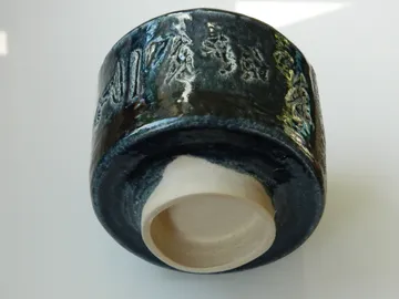 Ceramic cup displayed upside down indoors.