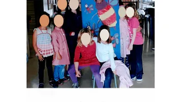 Gruppe von Kindern hält Bienenplakat drinnen.