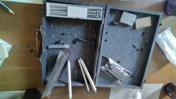 Kunstbedarf verstreut in einem geöffneten Koffer.