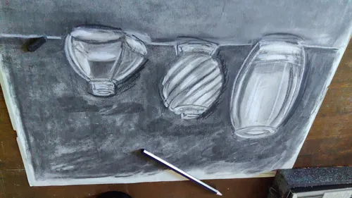 Charcoal drawing of glass bottles on paper.
