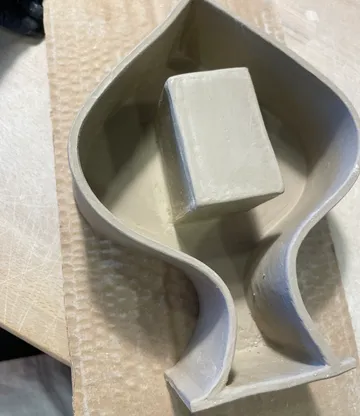 Tonform auf Pappe, auf Tisch liegend.