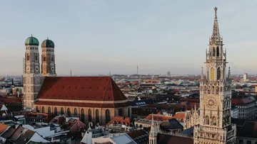 Kirche und Uhrturm in Münchner Stadtbild.