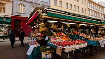 Obststand präsentiert Produkte auf Freiluftmarkt.