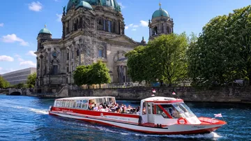 Touristenboot passiert Berliner Dom auf Fluss.