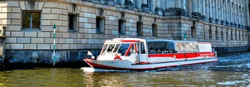 Boat cruising by a historic building.