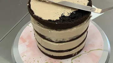 Schokoladenkuchen wird auf Tisch glasiert.