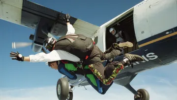 Zwei Fallschirmspringer springen aus einem Flugzeug.