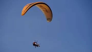 Tandem-Gleitschirmflieger schweben im klaren Himmel.