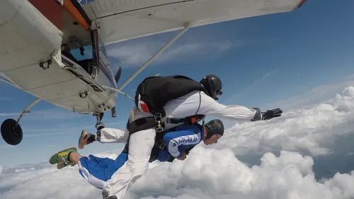 Tandem-Fallschirmspringer springen aus einem Flugzeug.