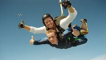 Zwei Fallschirmspringer im Tandemsprung, Himmelshintergrund.