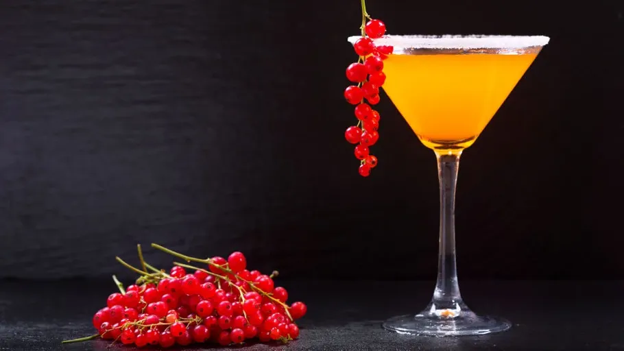 Cocktail with currants on black background.