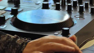 DJ steuert Mixer, stellt im Studio ein.