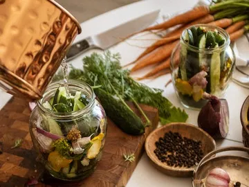 A glass is filled with vegetables and water.