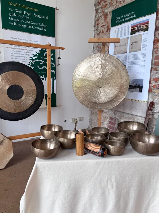 Gongs und Schalen drinnen auf Tisch ausgestellt.