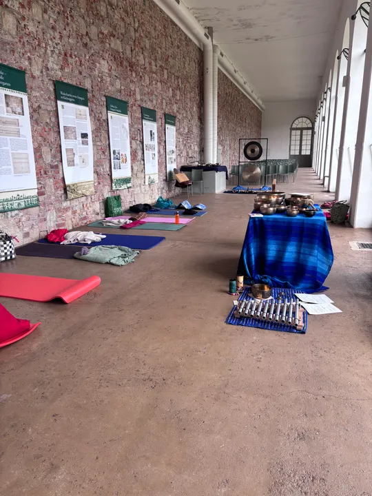 Yogamatten und Gongs in einer Galerie.