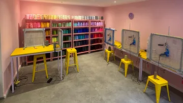 Workstations with yarn shelves in pink room.