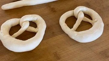 Ungebackene Brezeln auf Holzfläche.