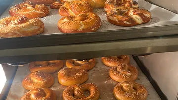 Gebackene Brezeln kühlen auf Metalltabletts.