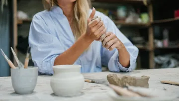 Person formt Ton in einem Kunststudio.