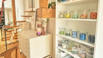 Glass jars with colorful tiles on shelves.