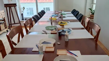 Art supplies on a table in a classroom.