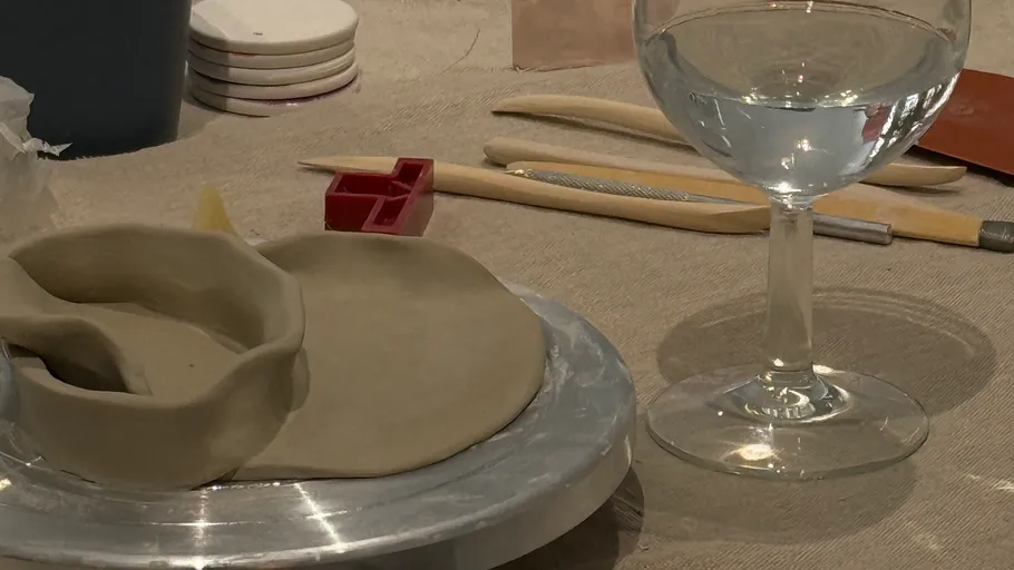 Clay sculpture and tools on a table.