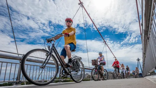 Radfahrer fahren mit Fahrrädern auf einer Brücke.