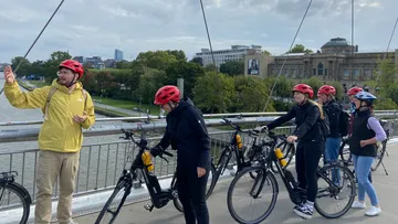 Gruppe mit Fahrrädern auf Stadtbrücke.