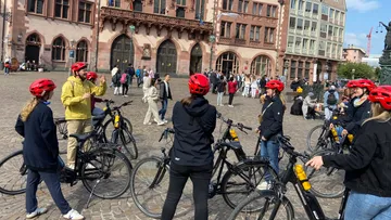 Radfahrer versammeln sich auf einem Stadtplatz.
